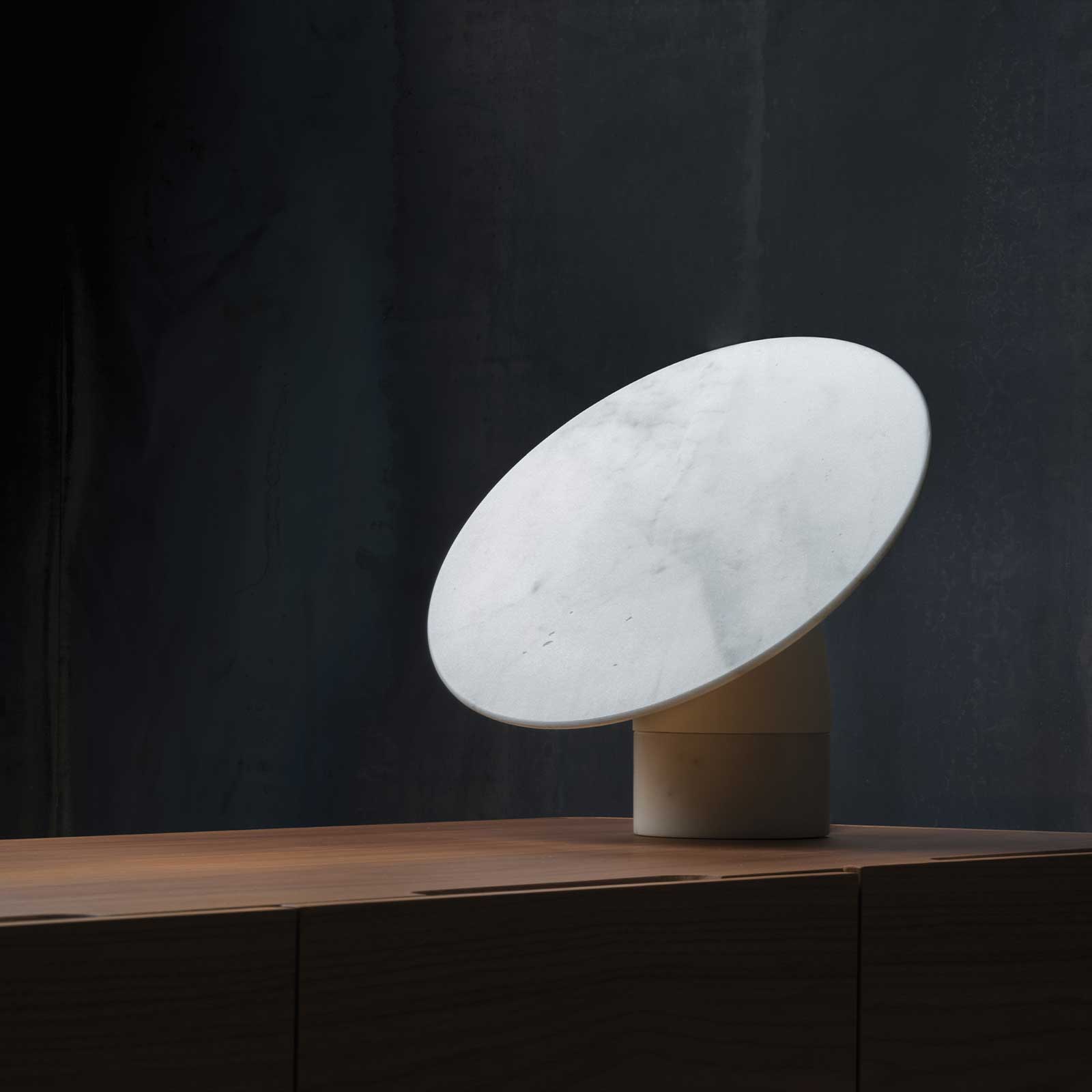 Aura object on a wooden sideboard, disc tilted, power off
